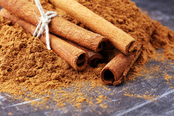 Ground cinnamon, cinnamon sticks, tied with jute rope and cinnamon powder in rustic style.