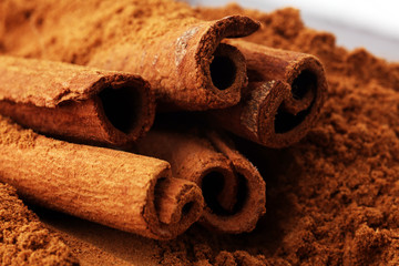 Ground cinnamon, cinnamon sticks, tied with jute rope and cinnamon powder in rustic style.