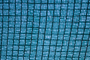 The texture of the woven mesh is blue. Fishnet. Background image of woven mesh fibers. The texture of nets for fishing.