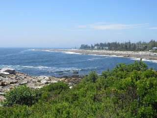 Fototapeta na wymiar View of ocean waves crashing on a rocky coast in Maine