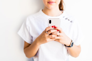 Close up of Young woman holding phone in her hands isolated on white background