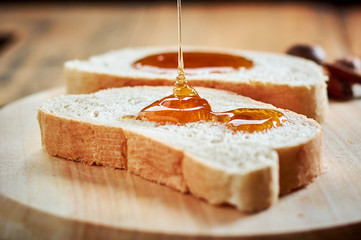 Pouring fresh honey on bread slices