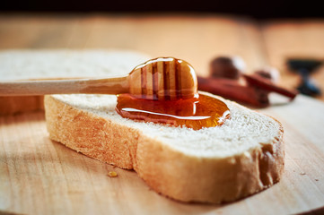 Pouring fresh honey on bread slices