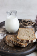 Loaf of sliced rye bread on old wooden tray. 