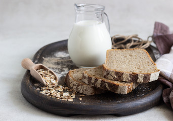 Loaf of sliced rye bread on old wooden tray. 