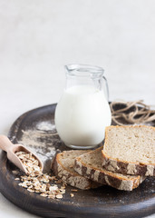 Loaf of sliced rye bread on old wooden tray. 