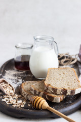 Loaf of sliced rye bread on old wooden tray. 