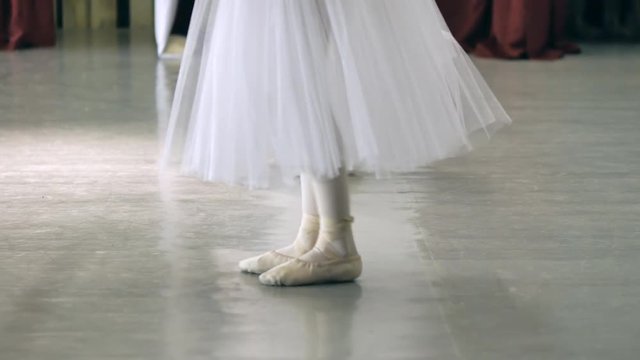 Ballet.Close-up of a girl's legs in white ballet shoes during ballet training. Element of classical dance. 4K