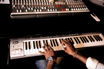 African man plays jazz on synthesizer in recording Studio