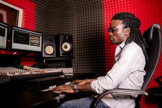 African man with dreadlocks in a recording studio