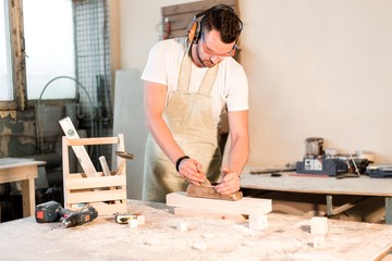 Carpenter planer planed wooden Board in the workshop for the workplace