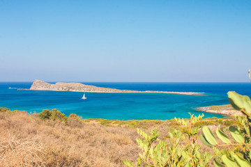 Naklejka na ściany i meble Beautiful beach of Crete with turquoise water. A popular tourist beach. Kolokitha beach. Peninsula Kalydon. Crete, Elounda,Greece.