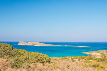 Fototapeta na wymiar Beautiful beach of Crete with turquoise water. A popular tourist beach. Kolokitha beach. Peninsula Kalydon. Crete, Elounda,Greece.