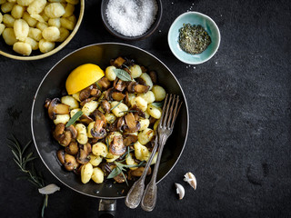 Prepared mushrooms and gnocchi dish on dark background with blank space,selective focus