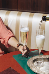 A glass of prosecco held by a girl in an elegant bar with vintage pop colors