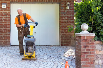Installation of brick pavers on a driveway.