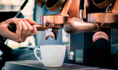 Close up of barista preparing fresh espresso on professional brewing machinery