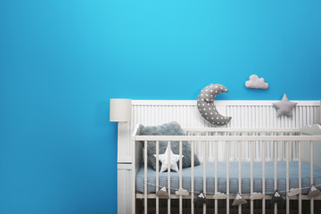 Baby room interior with crib near color wall