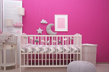 Baby room interior with crib near color wall