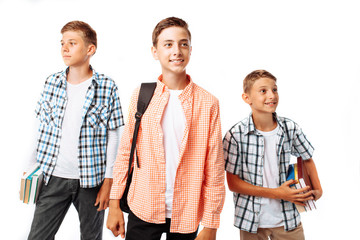 Boys teenagers, students or schoolchildren, on a white background in the Studio, go to school, preparing for the school day