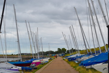 Colourful sailing boats lined up near the sea at Whitstable. Whitstable, Kent, UK