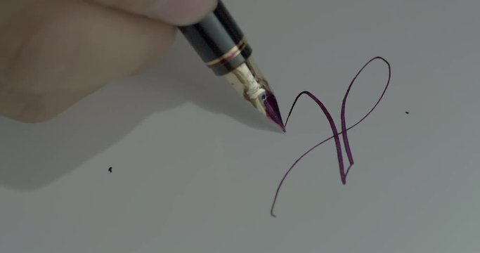 Writing the word attentive in calligraphy with a fountain pen.