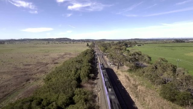 2 shots of country trains running along the Bairnsdale line through farmland near Nar Nar Goon, Victoria, Australia.