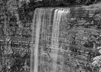 Beautiful waterfall cascading over tall rock layers