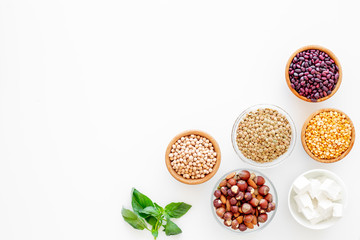 Vegan protein source. Legumes, nuts, cheese, spinach. Raw beans, chickpeas, lentil, almond, hazelnut on white background top view copy space