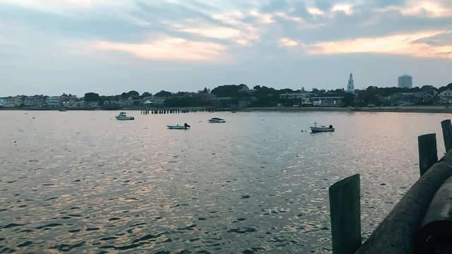 Birds flying in slow motion over the bay with boats at sunset