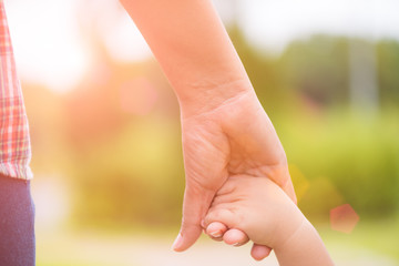 Close up mother holding a child's hand. Family and Mothers day concept.