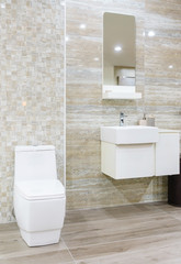 Modern spacious bathroom with bright tiles with toilet and sink.