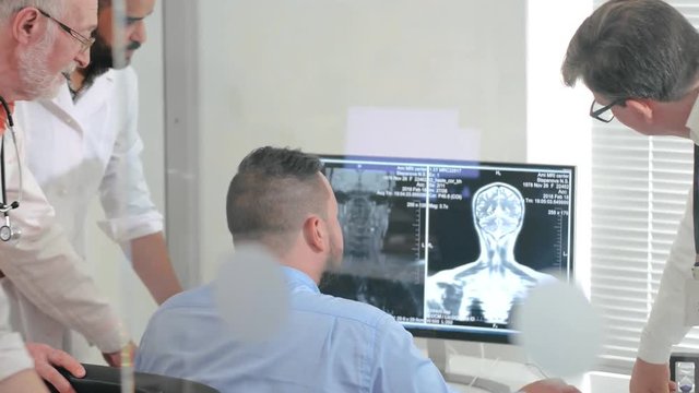 Team of doctors of research Institute studying x-ray image of human brain on computer. Scientists are studying diseases of human brain