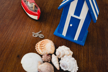 keys of a beach house next to wooden toy house with maritime motives.
