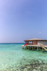 Maldives, Feb 8th 2018 - A part of the Cestara hotel over the blue water beach, calm waters in the lagoon in a clear sky in Maldives
