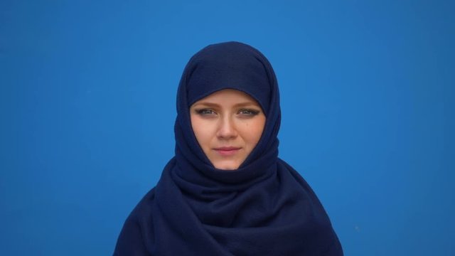 close up portrait of lovely young muslim business woman wearing hijab headscarf looking confident smiling calm professional ambitious over blue background