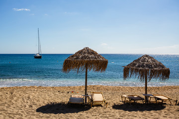 Sun loungers and straw umbrellas from the sun on the beach.