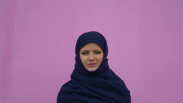 close up portrait of lovely young muslim business woman wearing hijab headscarf looking confident smiling calm professional ambitious over pink background