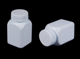 White plastic medicine bottle isolated on black background