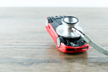 Stethoscope checking up the car on wooden table, Concept of car check up, repair and maintenance..