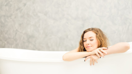 Obraz premium Young woman relaxing in bath.beautiful woman lying in bathtub.