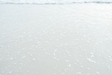 Soft wave of blue and green ocean/sea on sandy beach. Empty copy spac background.