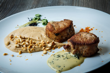 closeup two tasty pieces of grilled meat with puree and sauce