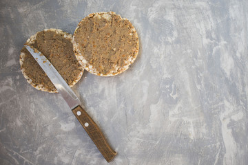 Closeup of a bread smeared with pate and a knife on a concrete background