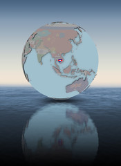 Cambodia on globe above water surface