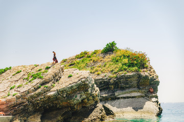 woman stand on the cliff in light dress at sunny day
