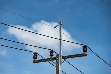 electric wire  on electrical pole with blue cloudy sky background