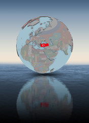 Turkey on globe above water surface