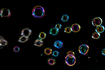 Soap bubbles on a dark background in motion.