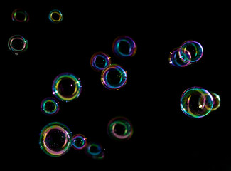 Soap bubbles on a dark background in motion.